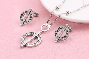 Macro detail of silver necklace and earrings set with roman numerals and rhinestones