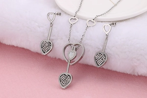 Détail d'un ensemble de bijoux cœur en argent avec nacre blanche et cristaux étincelants