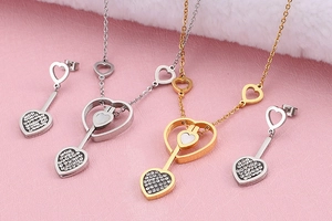 Détail de parures collier et boucles d'oreilles cœur en or et argent avec strass