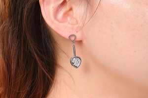 Gros plan de boucles d'oreilles cœur en métal sombre avec cristaux sur le mannequin