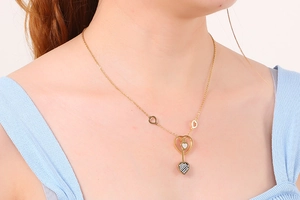 Gros plan d'un collier pendentif cœur doré sur un mannequin avec cristal incrusté étincelant