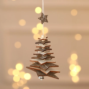 Handcrafted wooden Christmas tree ornament with bell and stars against warm bokeh light