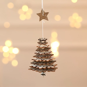 Detail of wooden snowflake pendant with a small bell against warm bokeh lights