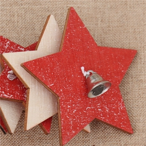 Close-up of wooden star ornaments with silver bells on burlap background