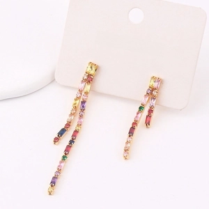 Detail of long tassel earrings with multicolored cubic zirconia on golden setting