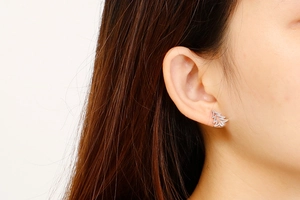 Close-up of minimalist silver stainless steel Christmas tree stud earrings worn by a model