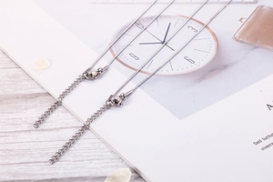 Close-up of the adjustable silver chain tail and lobster clasp on stainless steel necklaces