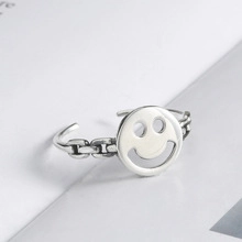 Macro view of silver U-shaped chain ring featuring a polished smiling face design