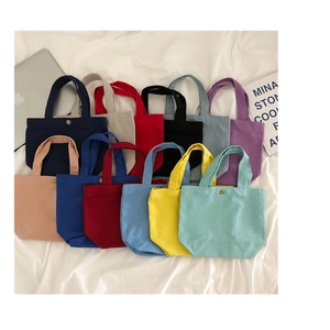 Colorful canvas lunch bags neatly arranged on a white cloth in an Ins-style lifestyle setup
