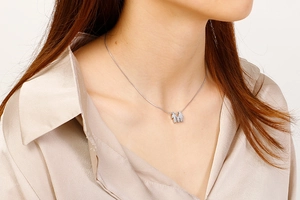 Dettaglio della collana familiare in acciaio argento con ciondoli a forma di persone sul modello