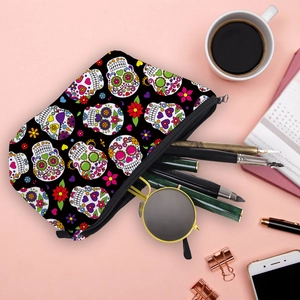 Waterproof skull print makeup bag organized on pink desk with travel accessories