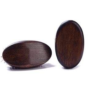 Detail view of two dark brown curved wooden beard brushes showing smooth natural wood grain