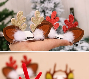 Détail de pinces à cheveux rennes de Noël avec bois scintillants et pompons blancs
