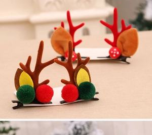 Détail de pinces à cheveux bois de renne avec pompons en peluche pour coiffure de Noël