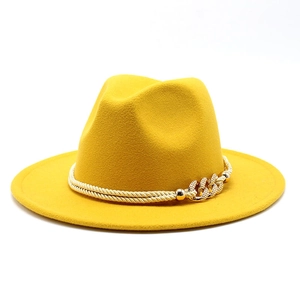 Détail d'un chapeau fedora jaune vif avec cordelette dorée et chaîne métallique décorative