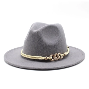 Détail d'un chapeau fedora gris à bord large avec chaîne dorée et corde tressée