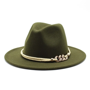Détail d'un chapeau fedora vert foncé avec corde tressée dorée et chaîne métallique