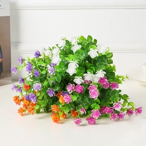 Detailed close-up of artificial ivy leaves and colorful flowers for wedding wall decor