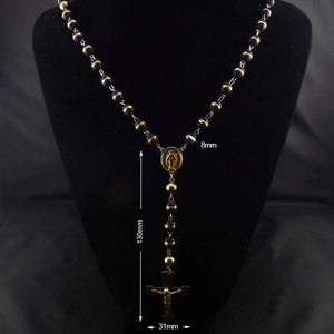 Detail of 8mm black matte rosary beads with gold Virgin Mary medal and crucifix pendant