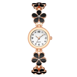 Detail of rose gold quartz watch with black flower petal bracelet and rhinestone accents