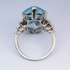 Detalle del anillo de cristal azul ovalado con diseño geométrico calado de estilo Art Déco