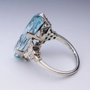 Anillo de plata con gran cristal azul y pavé de diamantes laterales en engaste de cuatro garras