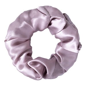 Close-up of pink silk hair scrunchie showing detailed texture and soft glossy sheen