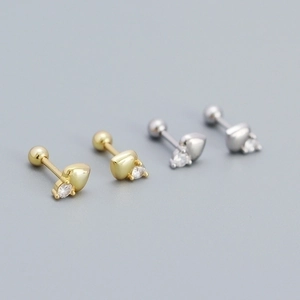 Macro shot of silver and gold heart stud earrings with cubic zirconia and screw backs