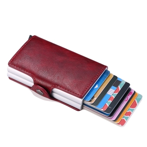 Detail shot of red leather pop-up wallet with metal mechanism and cards ejected