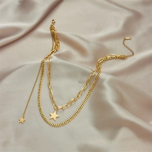 Double-layered gold titanium steel necklace featuring star pendants on beige silk