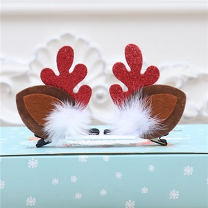 Détail de pinces à cheveux bois de renne de Noël avec paillettes rouges et pompons blancs