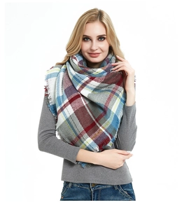 Detail of soft fabric texture and multicolor plaid pattern with tassel edge on the scarf