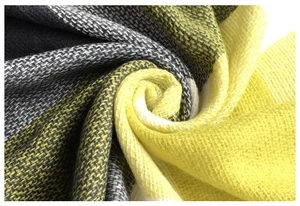 Close-up of soft yellow and grey checkered cashmere-like knit fabric texture and weave
