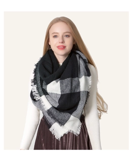 Close-up of black and white checkered scarf with soft fringe details worn by model