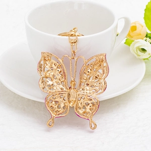 Golden butterfly keychain with rhinestone wings and pink enamel on elegant white background
