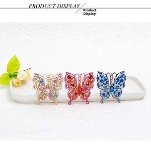 Detailed view of colorful rhinestone butterfly charms in gold, pink, and blue finishes