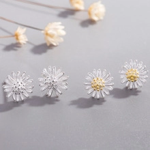 Dettaglio macro di orecchini in argento a forma di margherita con trama floreale fine