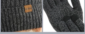 Detailed knit texture of grey winter hat with leather logo and touchscreen gloves