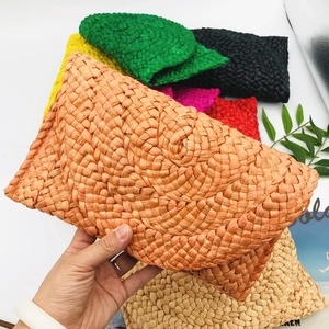 Handmade woven corn husk straw clutch bags available in multiple vibrant colors