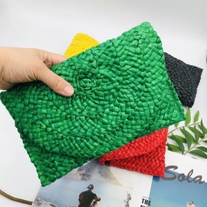 Detailed close-up of handmade corn husk woven clutch with multi-color layered texture