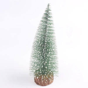 Mini green Christmas tree with white snow effect and round wooden base on white background