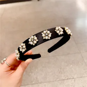 Detail of wide headband with handmade floral pearls and sparkling rhinestones on black satin