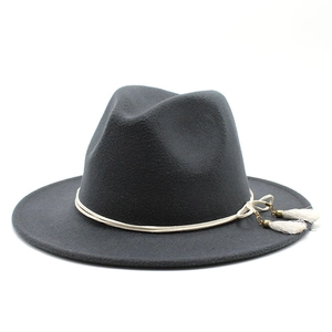 Detail of dark grey wool fedora hat featuring white tassel accents and woven rope band