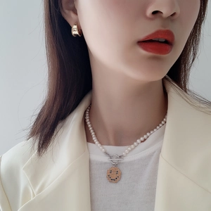 Close-up of model wearing S925 silver gold hoop earrings and pearl smiley face necklace