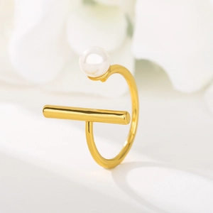 Macro shot of 18K gold plated open ring featuring a white pearl and geometric metal bar
