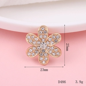 Golden flower charm with white rhinestones and a central crystal, 25mm height