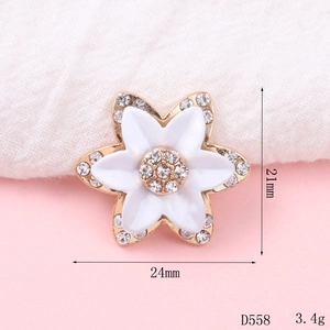 Sparkling crystal flower charm with white enamel petals and gold metallic frame