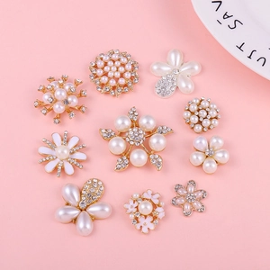 Flat lay of gold floral pearl and rhinestone charms for DIY jewelry and phone case decor