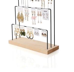 Three-tier wood and black metal earring display stand showing various fashion jewelry