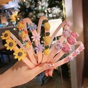 Close-up of pink children's headbands with sunflower and cute cartoon animal charms